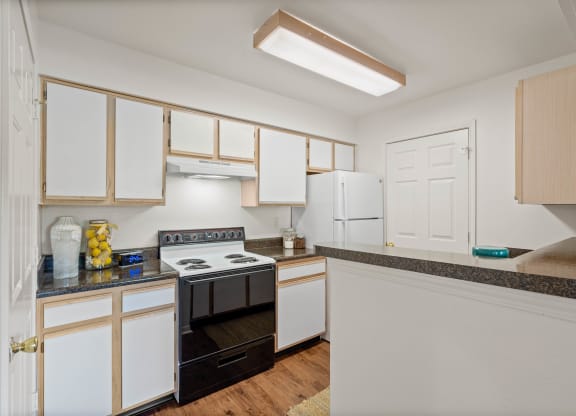 a kitchen with white cabinets and black appliances