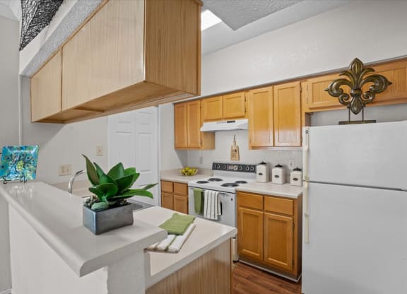 a kitchen with a white refrigerator freezer next to a stove top oven at Creekview Apartment Homes, Texas, 75254