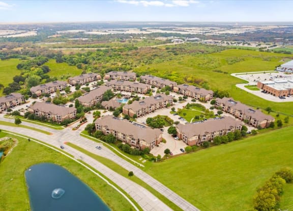 an aerial view of a subdivision with a lake in the foreground