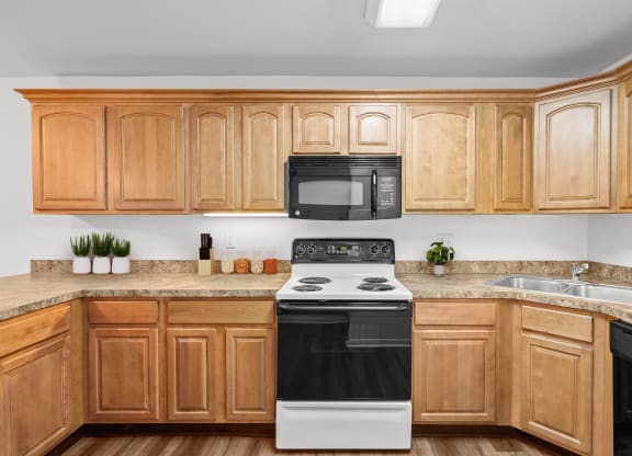 a kitchen with wooden cabinets and a black and white stove top oven