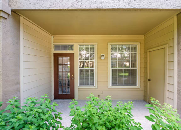 a front porch with a door and windows