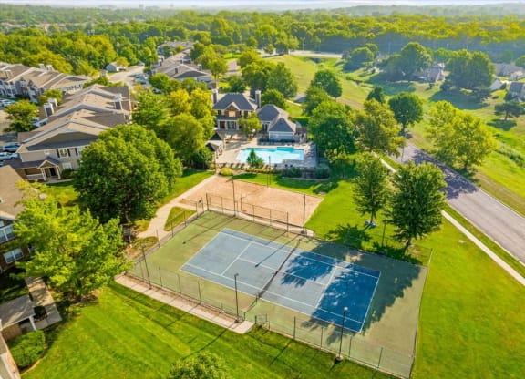 an aerial view of a house with a tennis court in the foreground and a swimming pool inat Stonebriar Woods Apartments, Kansas, 66213