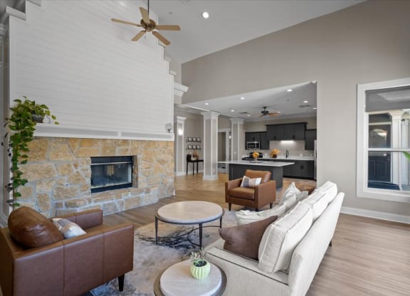 A living room with a stone fireplace and a brown leather couch.