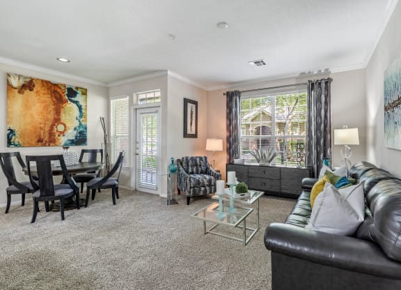 a living room with a couch and a chair in front of a table with a chair and