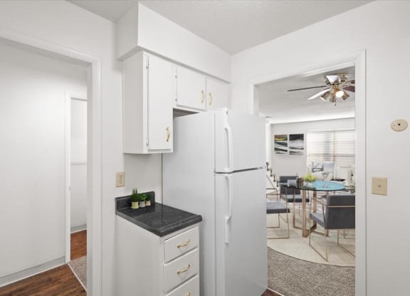 a kitchen with white cabinets and a white refrigerator