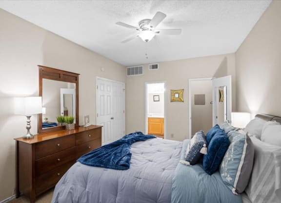 a bedroom with a bed and a ceiling fan at Creekview Apartment Homes, Dallas, 75254