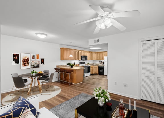 A living room with a storage closet, ceiling fan, and dining space.