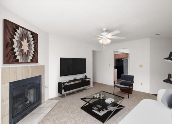 a living room with a fireplace and a tv at Deerfield Apartments, Olathe, KS