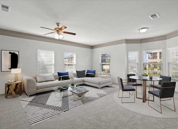 a living room with a couch a table and a ceiling fan at Stonepost Crossing Apartments, Overland Park, KS, 66213