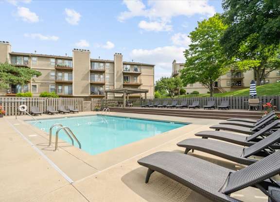 Pool surrounded by Lounge chairs at Cloverset Active Adult Apartments, Kansas City, MO