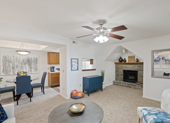 a living room with a fireplace and a ceiling fan at Waterford Place Apartments & Townhomes, Overland Park, 66210
