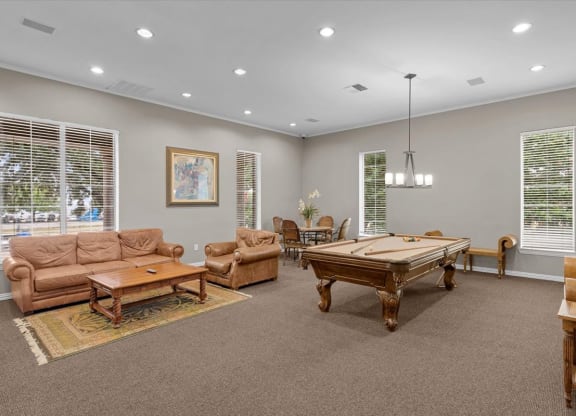 a game room with a pool table and couches at The Clairborne Apartment Homes, Grand Prairie, TX 