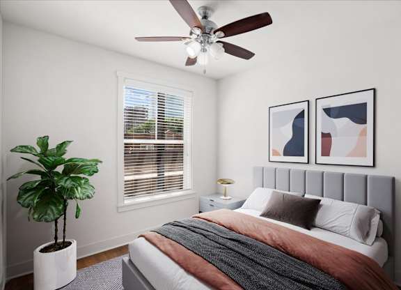 A bedroom with a ceiling fan and window at The Mirabelle pet-friendly apartments on the Plaza in Kansas City, MO