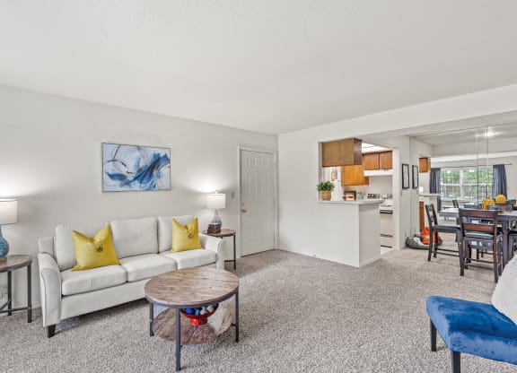 a living room with a white couch and yellow pillows at Pebblebrook, Kansas