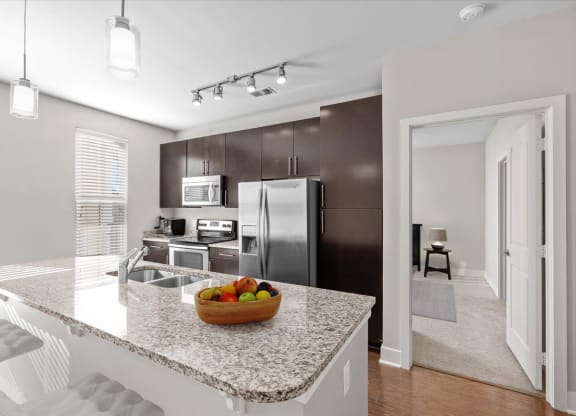 a kitchen with a granite counter top and a stainless steel refrigerator