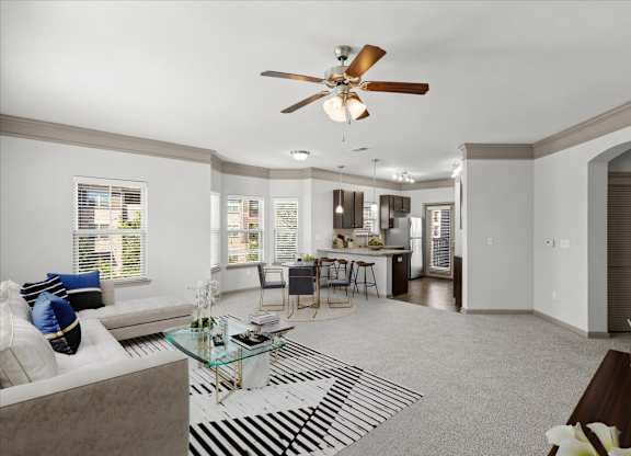 a living room with a couch a table and a ceiling fan at Stonepost Crossing Apartments, Overland Park, 66213