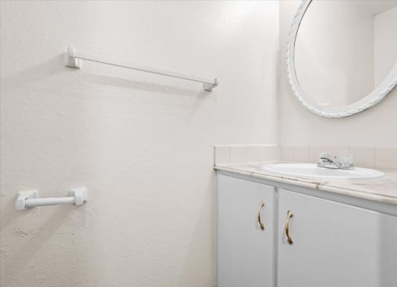 a white bathroom with a sink and a mirror