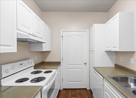A white door is in the middle of a kitchen.