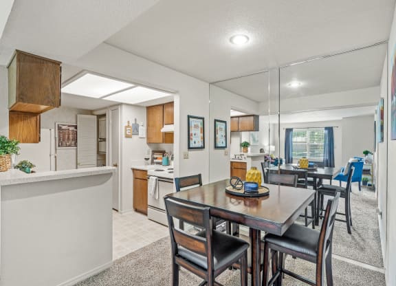a dining area with a table and chairs and a kitchen in the background at Pebblebrook, Kansas, 66212