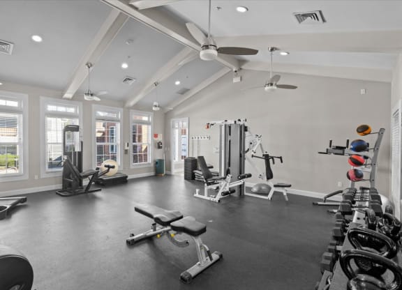 A spacious gym with a variety of equipment and a large mirror on the wall.