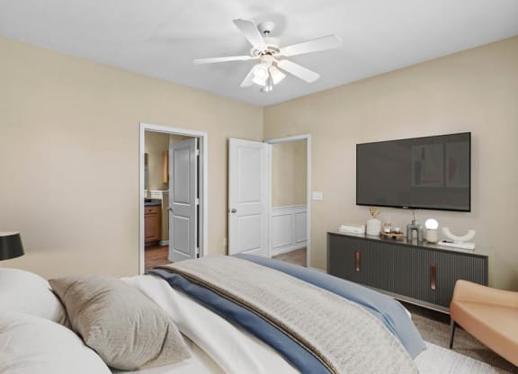 A bedroom with a ceiling fan and attached bathroom