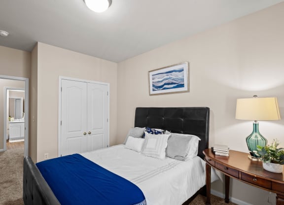a bedroom with a bed and a nightstand with a lamp at Creekside, Overland Park, 66213