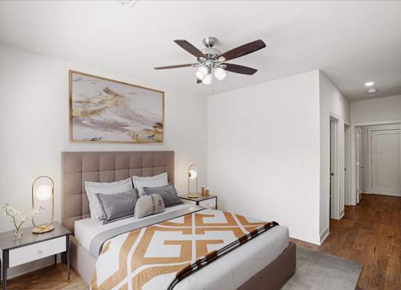 A bedroom with a ceiling fan and hallway closet.