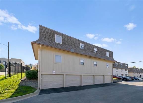 A two-story building with a garage door and a driveway in front. at Malvern Hill Apartment Homes, 66103