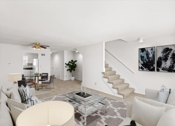 a living room with couches and a table and a staircase