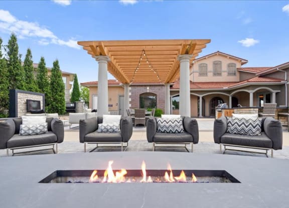 a patio with chairs and a fire pit