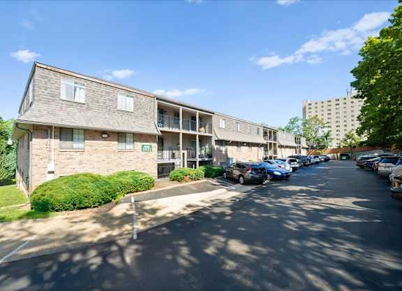 A sunny day at the apartment complex with cars parked on the street. at Malvern Hill Apartment Homes, 66103, Kansas
