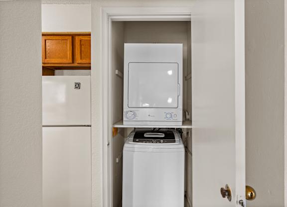 A white washing machine is in a small laundry room.