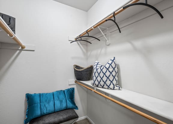 a closet with a shelf and a chair