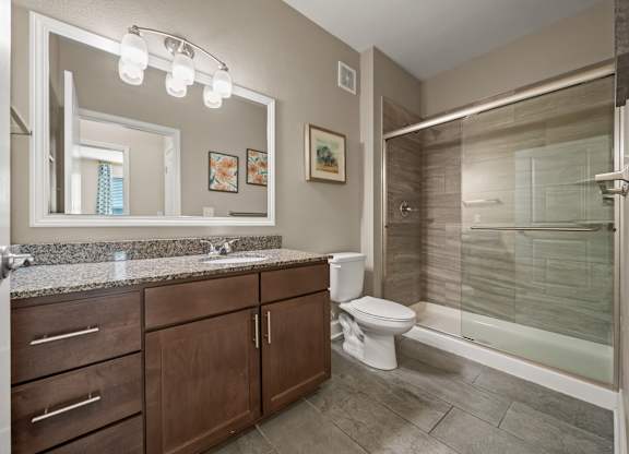 A bathroom with a sink, toilet, and shower.