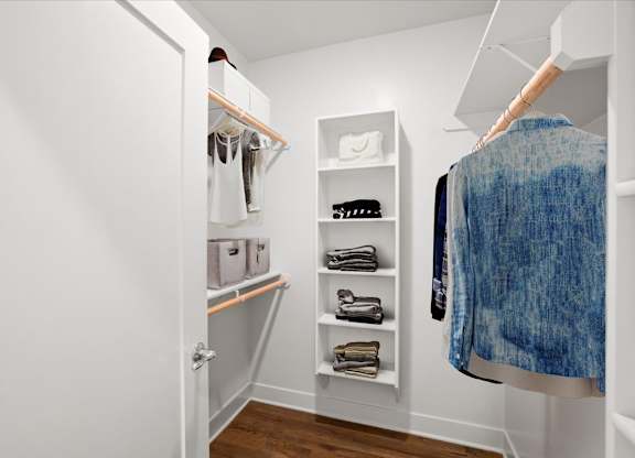 A large walk-in closet with built-in shelves, shoe storage, and clothing racks.