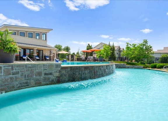 a large swimming pool with a building in the background