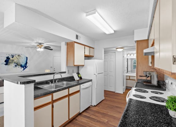 a kitchen with white appliances and wooden cabinetsat Stonebriar Apartments, Kansas, 66213
