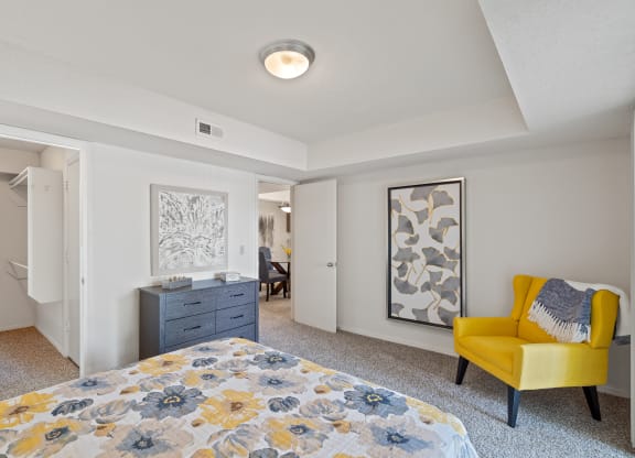 a bedroom with a bed and a dresser at Waterford Place Apartments & Townhomes, Overland Park, KS