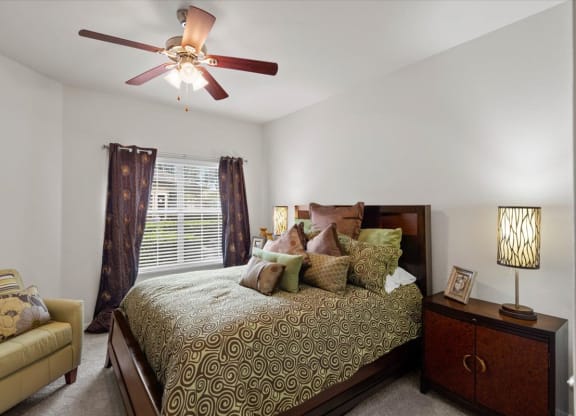 a bedroom with a bed and a ceiling fan