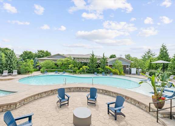A pool surrounded by blue chairs and a stone patio.