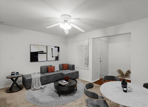 a living room with a round table and a ceiling fanat Millcreek Woods Apartments, Olathe, KS