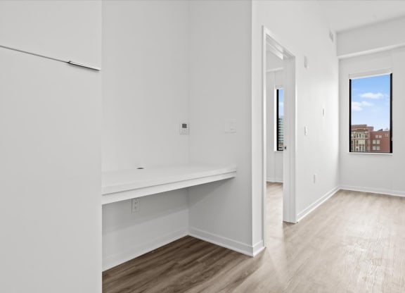 an empty room with white walls and a white refrigerator
