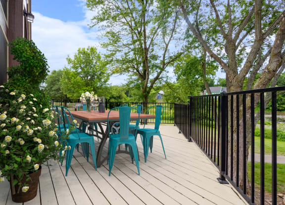 a patio with a table and chairs on a wooden deckat Millcreek Woods Apartments, Kansas, 66061