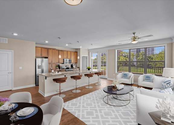 a living room and kitchen with a large window at The Dorset, Kansas City, MO
