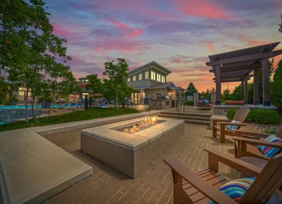a patio with chairs and a fire pit