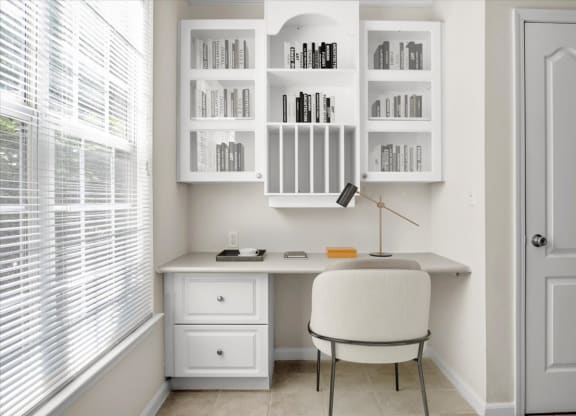 a home office with a white desk and chair and a window