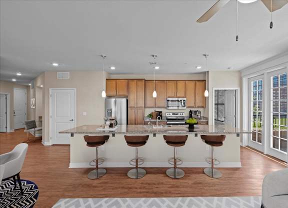 a kitchen and living room with a large island at The Dorset, Kansas City, 64112