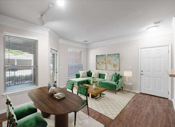 A living room with a green couch and a wooden table. at Somerset Oaks Apartment Homes, Kansas
