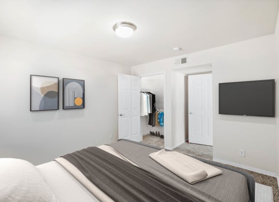 a bedroom with a large bed and a television on the wall at Stonebriar Woods, Overland Park