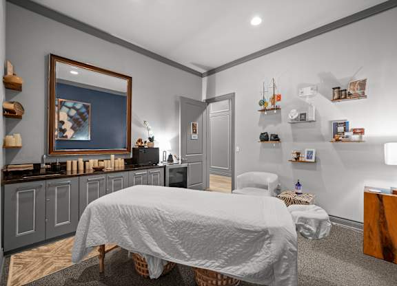 A bedroom with a bed, a nightstand, and a painting on the wall.